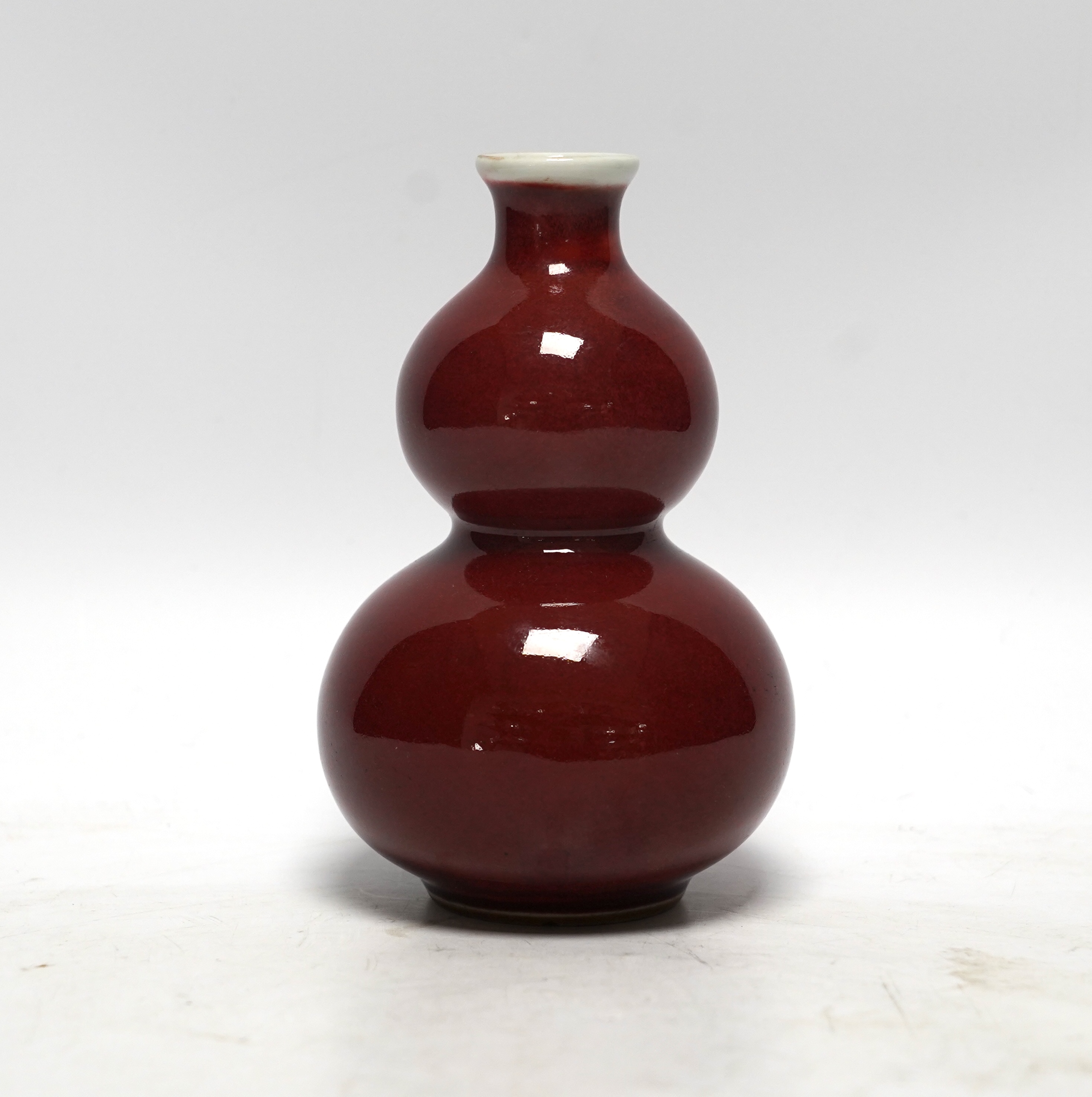 A Chinese sang de boeuf double gourd vase, 13cm high. Condition - good